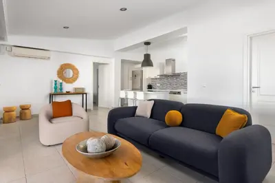 a living room with a blue couch and a table at Villa Rocabella with heated pool & jacuzzi in Lindos in vlicha