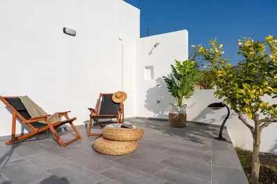 a patio with two chairs and a table at Giorgio Deluxe Studio in Kattavía