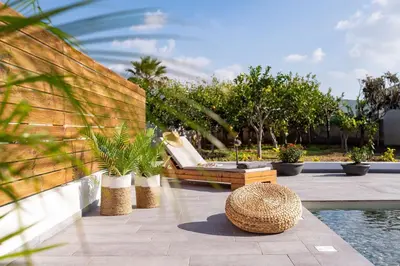 a patio with a bench and plants next to a pool at Giorgio Deluxe Studio in Kattavía