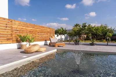 a backyard with a pool with a bench and a fountain at Giorgio Deluxe Studio in Kattavía