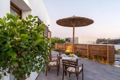 a patio with a table and chairs and an umbrella at Giorgio Deluxe Studio in Kattavía
