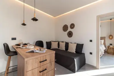 a bedroom with a bed and a desk with chairs at Giorgio Deluxe Studio in Kattavía