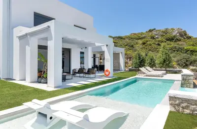a villa with a swimming pool and a house at Villa La Bianca in Koskinou