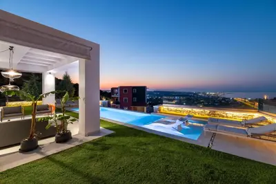 a pool on the roof of a building at night at Villa La Bianca in Koskinou