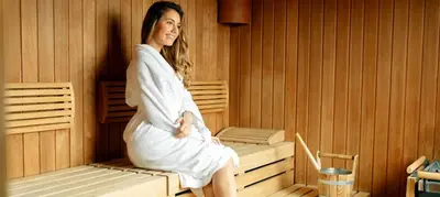 a woman is sitting in a sauna at Villa Equinox in Ixia