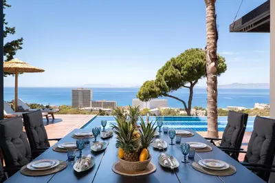 a blue table with plates and bowls of food on it at Villa Equinox in Ixia