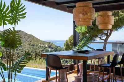 a dining room with a table and some plants at Villa Equinox in Ixia