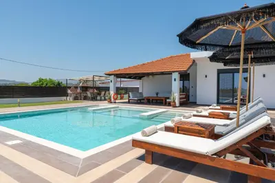 a villa with a swimming pool and a house at Elysian Villa in Afantou