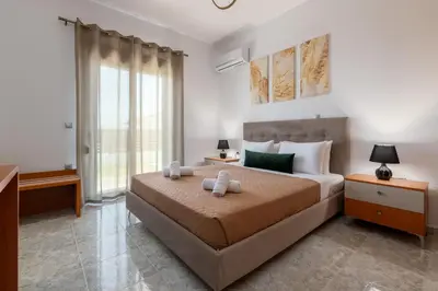 a bedroom with a bed and a large window at Elysian Villa in Afantou