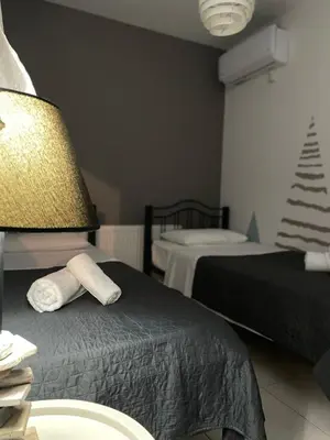 a hotel room with two beds and a lamp at Casa de Manu in Rhodes Town