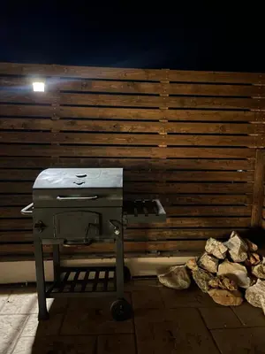 a grill sitting on a patio next to a wooden wall at Casa de Manu in Rhodes Town