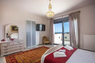 a bedroom with a large bed and a large window at Villa de Manu in Rhodes Town