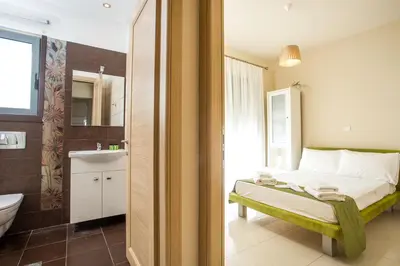 a bedroom with a bed and a bathroom with a sink at Villa de Manu in Rhodes Town