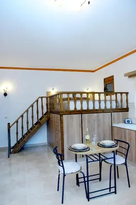 a dining room with a table and chairs and a staircase at Venus Island Studios in Líndos