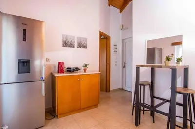 a kitchen with a stainless steel refrigerator and a counter at MEGAT SEAVIEW AND SEASIDE APARTMENTs in Ialyssos