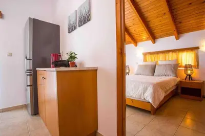 a bedroom with a bed and a dresser at MEGAT SEAVIEW AND SEASIDE APARTMENTs in Ialyssos