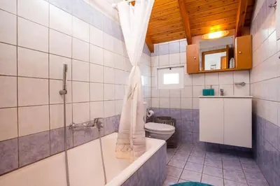 a bathroom with a tub and a toilet and a shower at MEGAT SEAVIEW AND SEASIDE APARTMENTs in Ialyssos