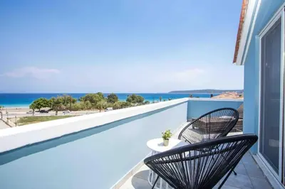 a balcony with two chairs and a view of the ocean at MEGAT SEAVIEW AND SEASIDE APARTMENTs in Ialyssos