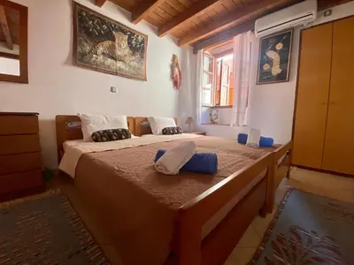 a bedroom with two beds and a window at Villa Afroditi in Halki