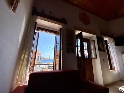 a living room with a couch and a large window at Villa Afroditi in Halki