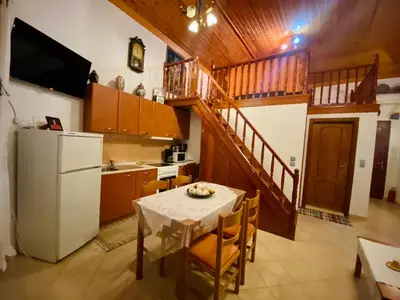 a kitchen with a table and a white refrigerator at Villa Afroditi in Halki