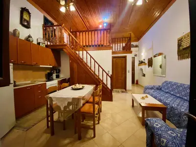 a kitchen and living room with a table and a couch at Villa Afroditi in Halki
