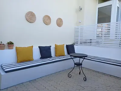 a bench in a room with pillows and a table at Beach house 30 in Ialyssos