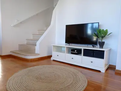 a living room with a tv on a white entertainment center at Beach house 30 in Ialyssos