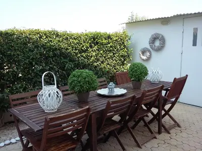 a wooden table with chairs and a vase on it at Beach house 30 in Ialyssos