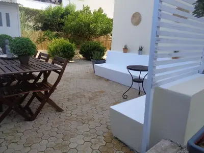a patio with a wooden table and chairs at Beach house 30 in Ialyssos