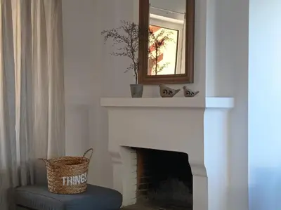 a fireplace with a mirror and a basket on it at Beach house 30 in Ialyssos