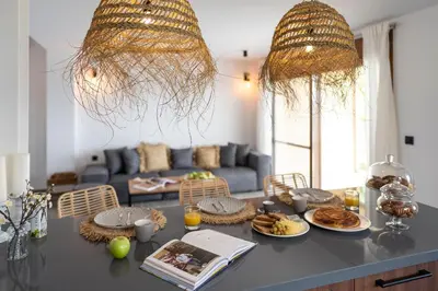 a living room with a table with plates of food at Luxury NissoVilla with Private Pool & Sea Views in Kolimbia