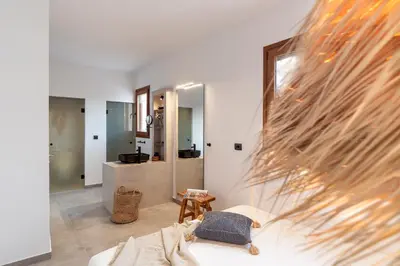 a living room with a white couch and a mirror at Luxury NissoVilla with Private Pool & Sea Views in Kolimbia