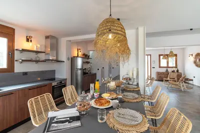 a kitchen and dining room with a table and chairs at Luxury NissoVilla with Private Pool & Sea Views in Kolimbia