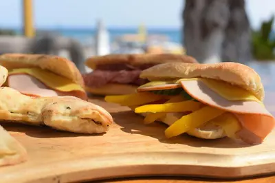 a group of sandwiches on a wooden cutting board at Marini Seaside in Faliraki