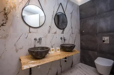 a bathroom with two sinks and two mirrors at Marini Seaside in Faliraki