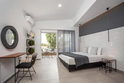 a bedroom with a bed and a table and chairs at Marini Seaside in Faliraki