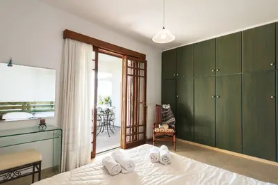 a bedroom with green cabinets and a bed and a balcony at Emerald Dawn Villa in Pefki Rhodes
