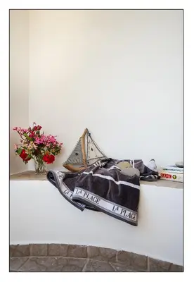 a shelf with a blanket and a vase with flowers at Emerald Dawn Villa in Pefki Rhodes