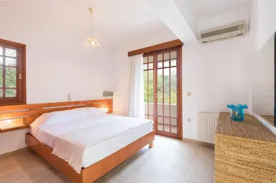 a bedroom with a large bed and a window at Emerald Dawn Villa in Pefki Rhodes