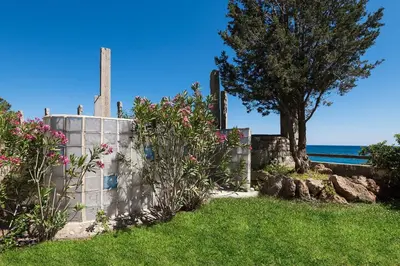 a garden with a tree and a stone fence at Emerald Dawn Villa in Pefki Rhodes
