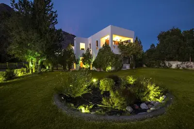 a large white house with a garden at night at Emerald Dawn Villa in Pefki Rhodes