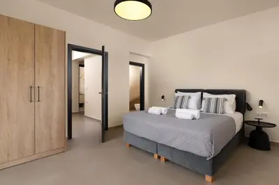 a bedroom with a large bed and a sliding glass door at Pantheon Luxury Villas Rhodes Island in Afantou