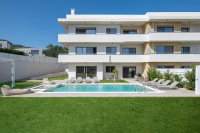 a villa with a swimming pool in front of a building at Pantheon Luxury Villas Rhodes Island in Afantou
