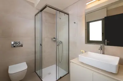 a bathroom with a shower and a toilet and a sink at Pantheon Luxury Villas Rhodes Island in Afantou