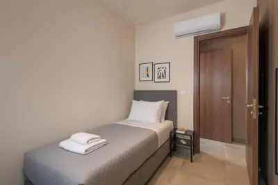 a bedroom with a bed with two towels on it at Lucian City Apartments in Rhodes Town