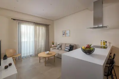 a white kitchen and living room with a couch at Lucian City Apartments in Rhodes Town