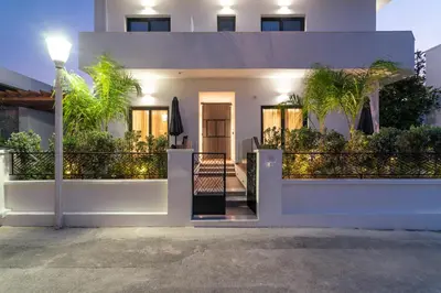 a white house with a balcony with plants at Lucian City Apartments in Rhodes Town