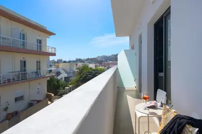 a balcony with a table and a glass of wine at Lucian City Apartments in Rhodes Town
