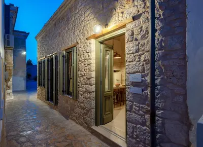 a stone building with a green door on a street at Villa Phaedra in Halki